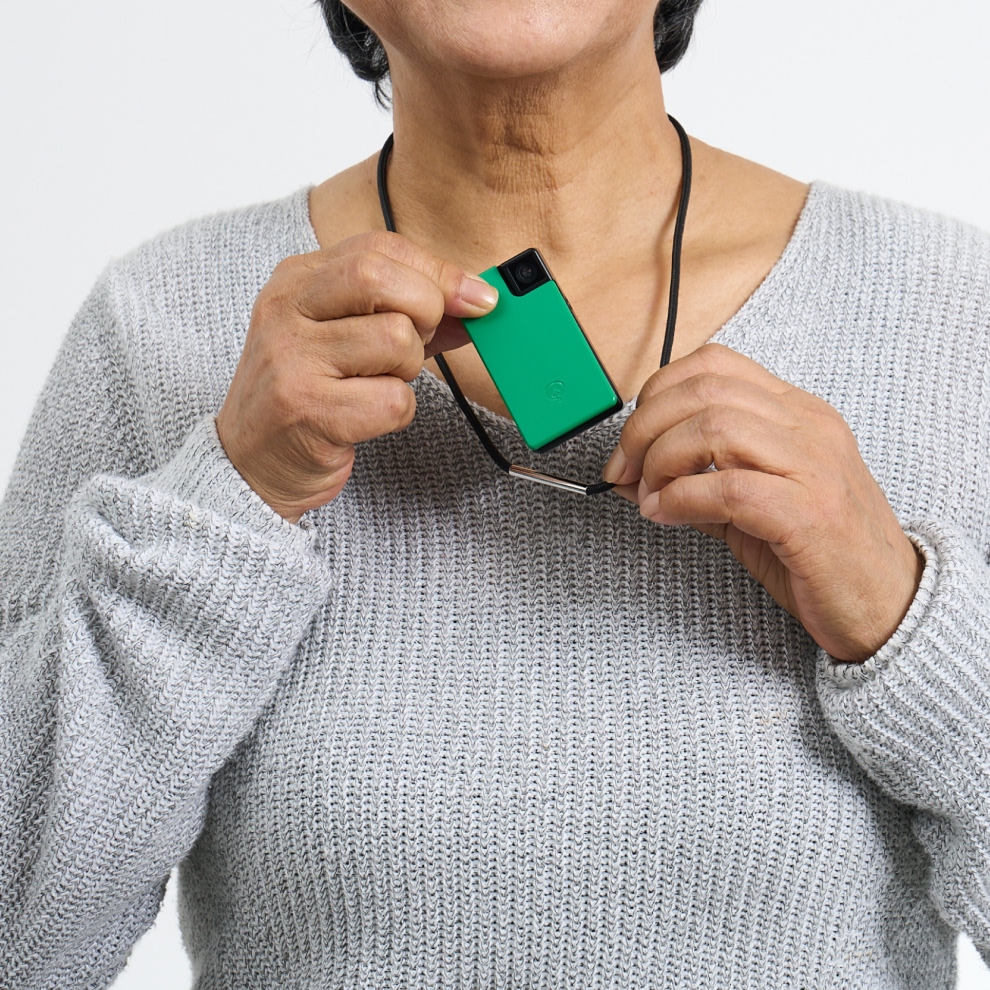 年配の女性が付属のストラップを用いて Saveclip を装着する様子。