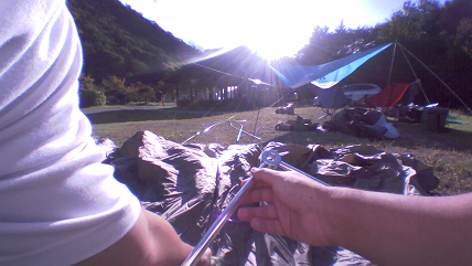 Saveclip をつけてキャンプ場でテントを広げている様子。